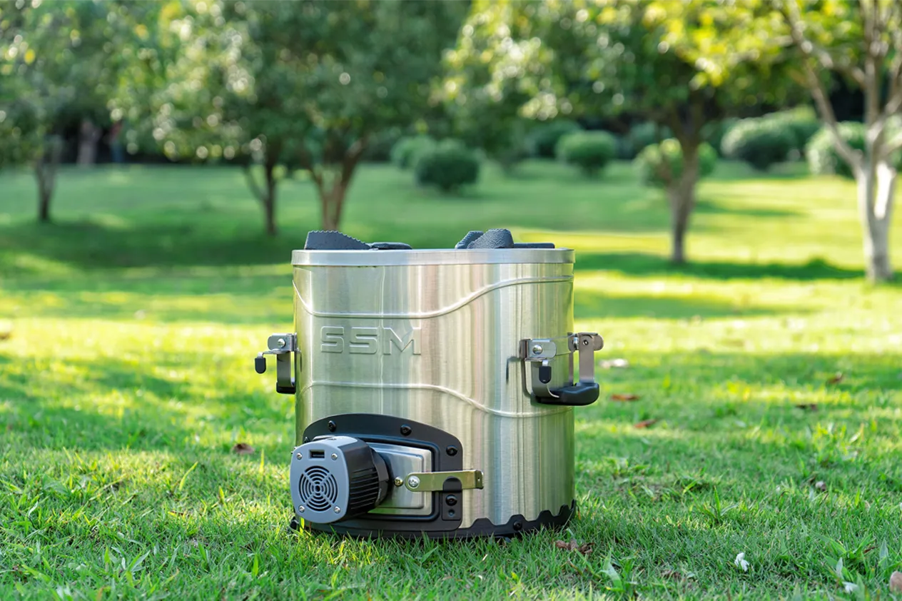 SSM brand portable biomass pellet burning cookstove set up in an outdoor backyard or garden setting.